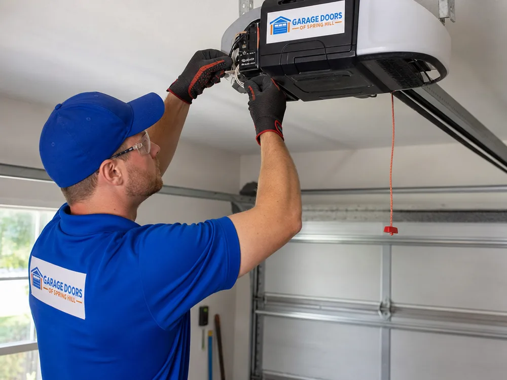 Contractor adjusting opener travel limits at a ceiling-mounted motor unit